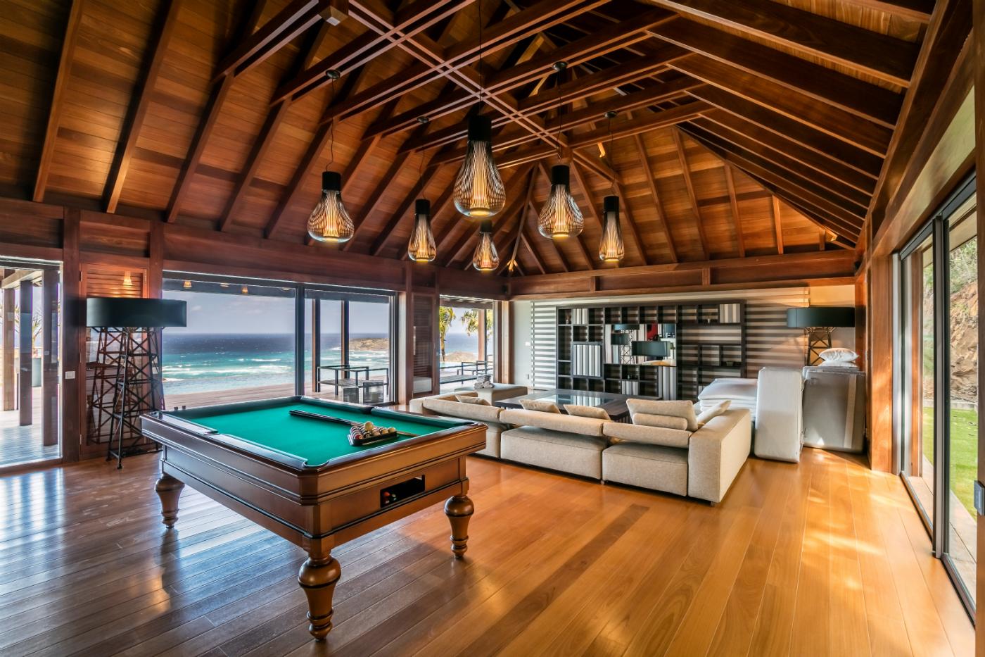 Intérieur villa luxe Saint-Barthélemy — charpente bois, billard, vue mer